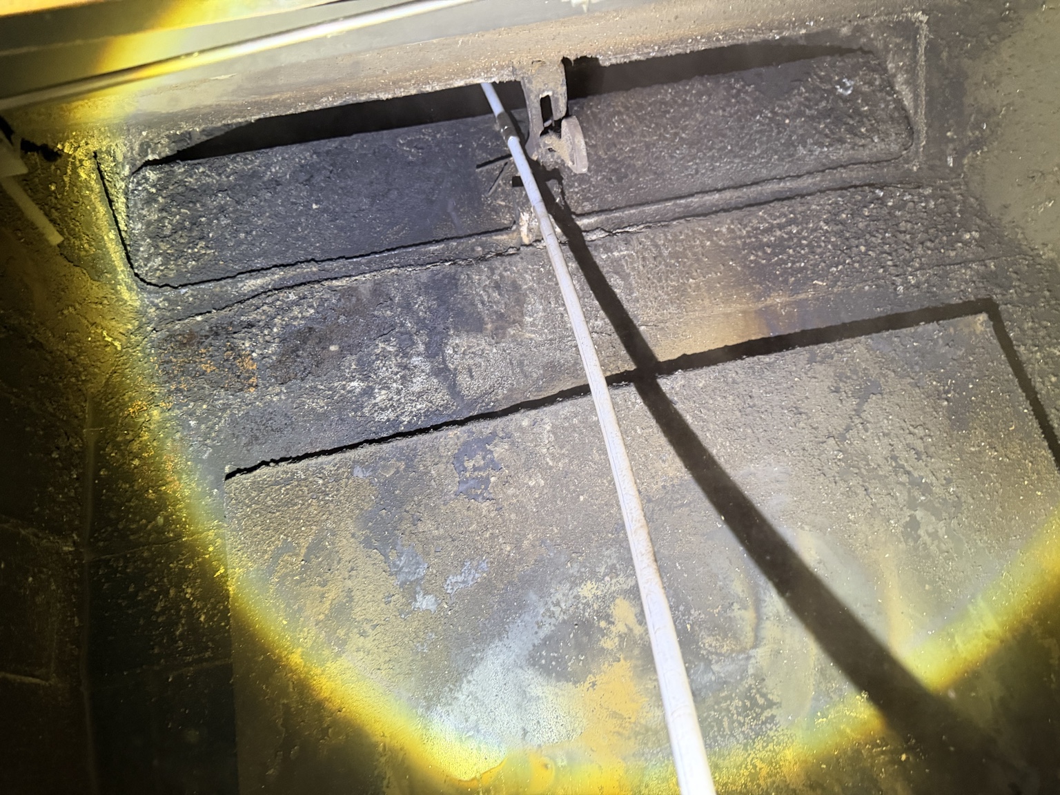Cleaning rod inside a rectangular fireplace damper