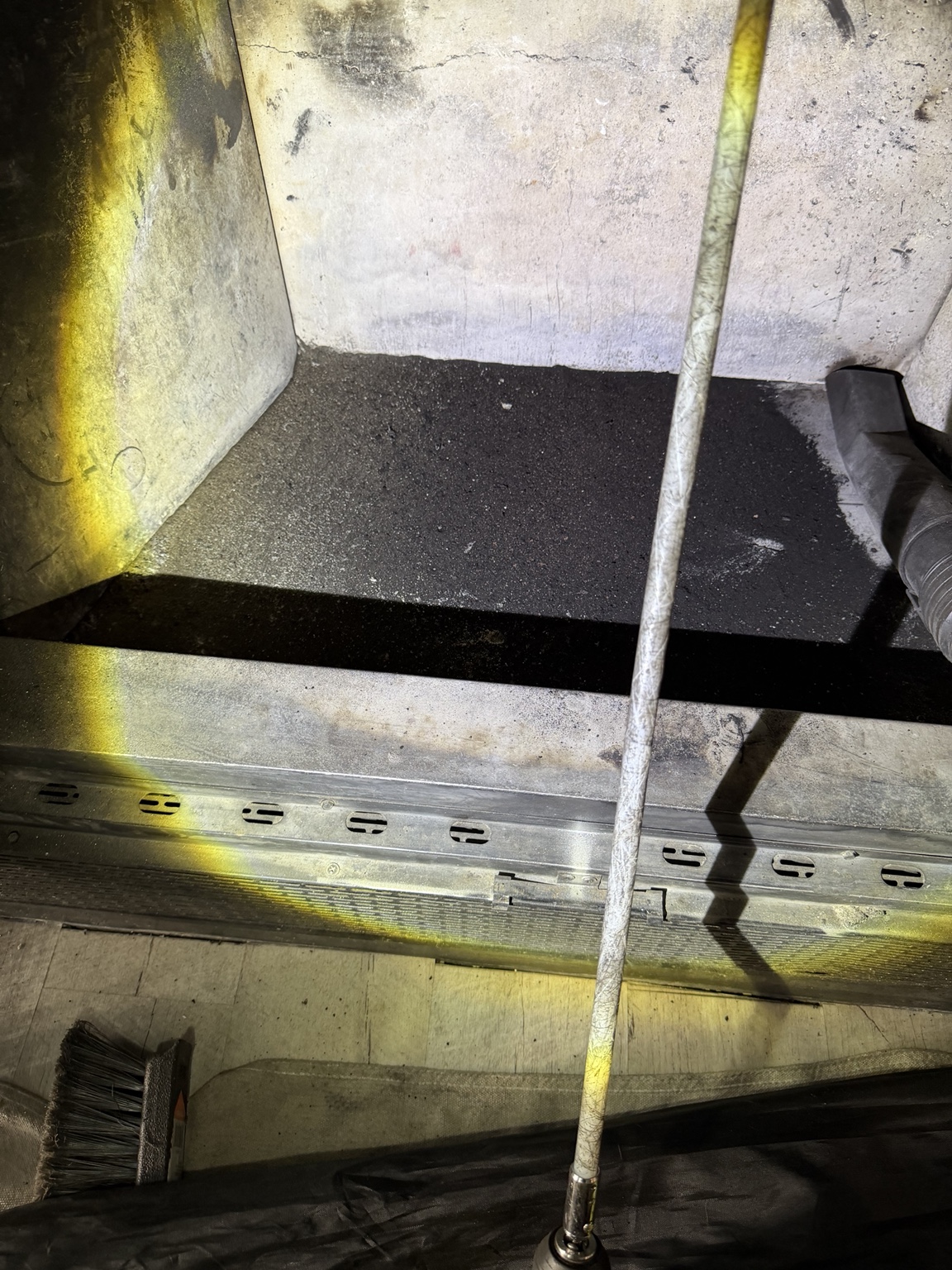 Firebox with soot debris and a cleaning hose