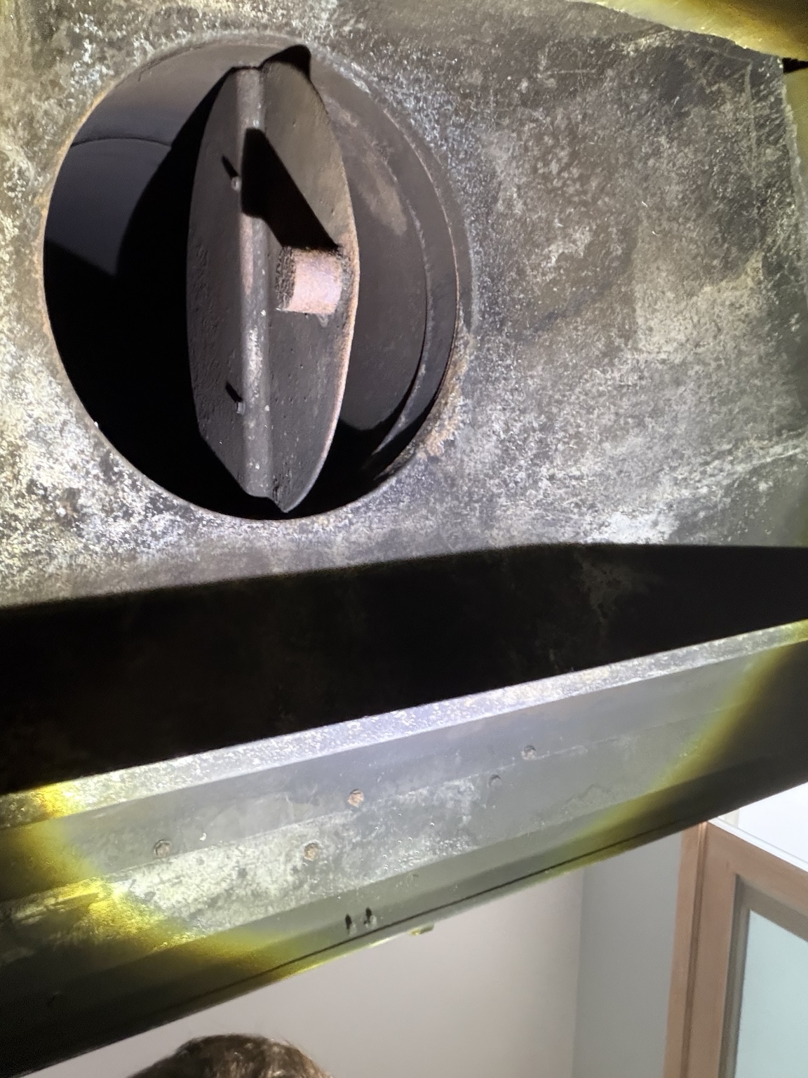 Open round fireplace damper viewed from below
