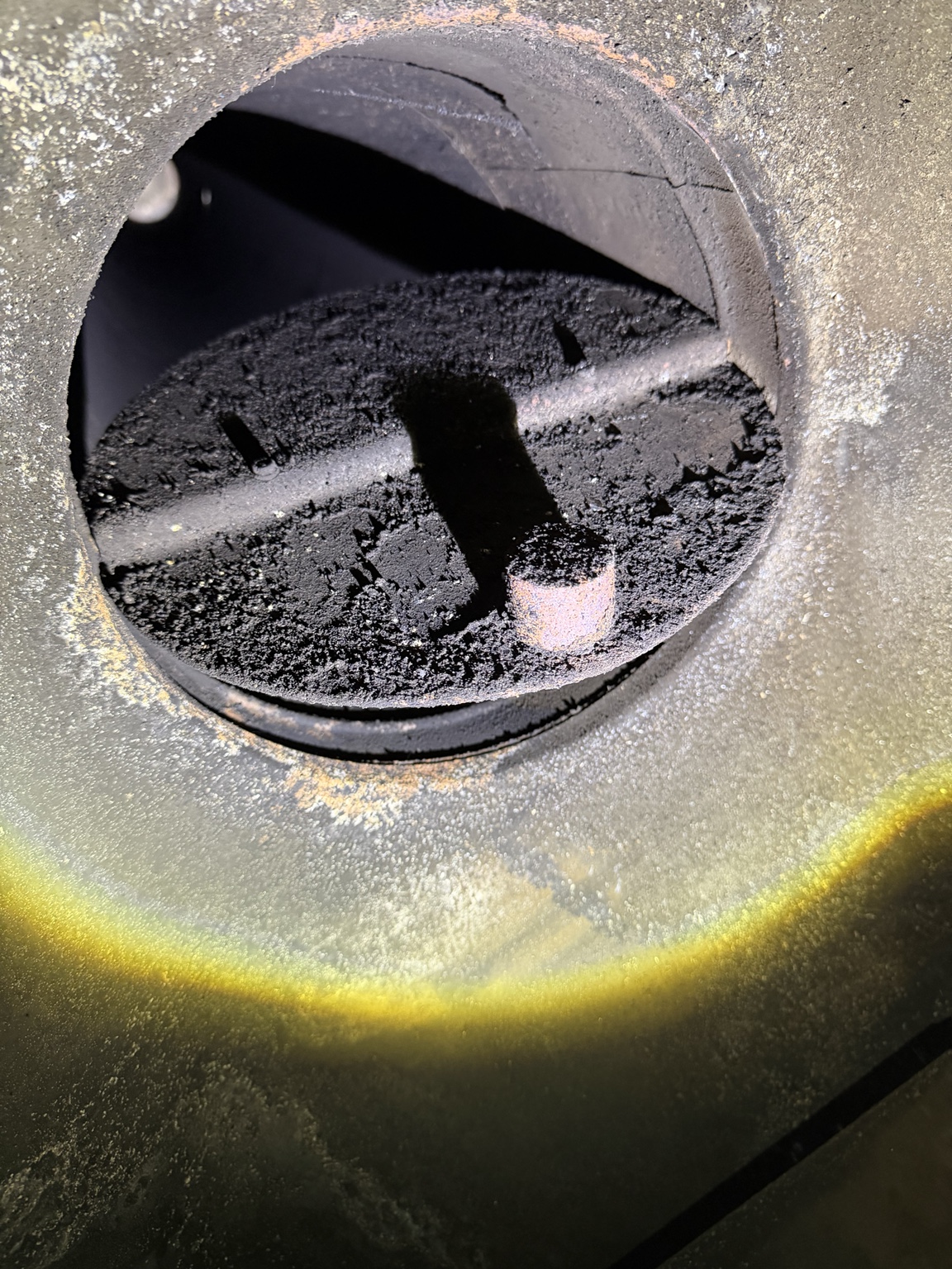 Soot deposits around a round fireplace damper